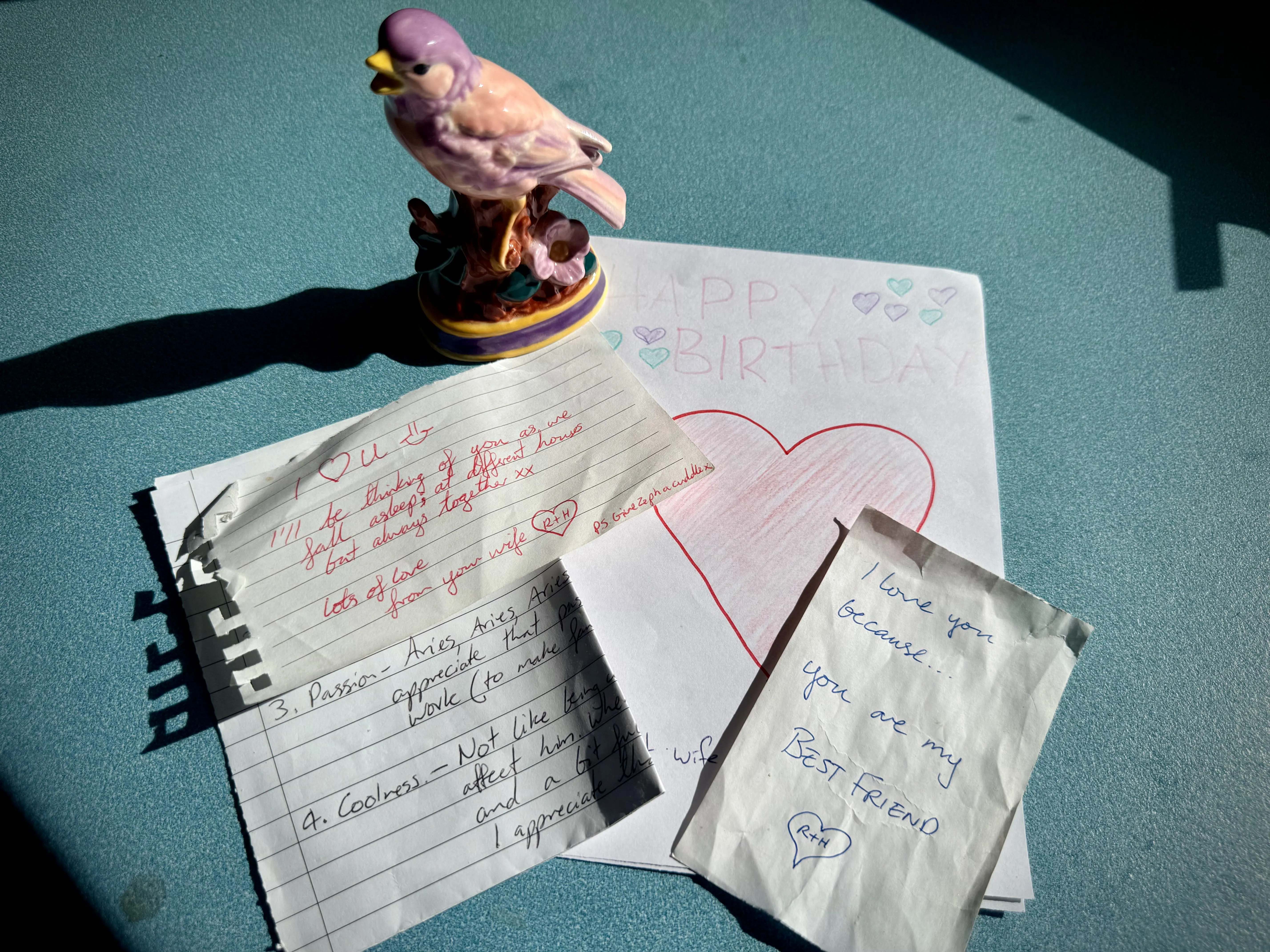 Handwritten notes, a handmade birthday card and a small sentimental bird figurine