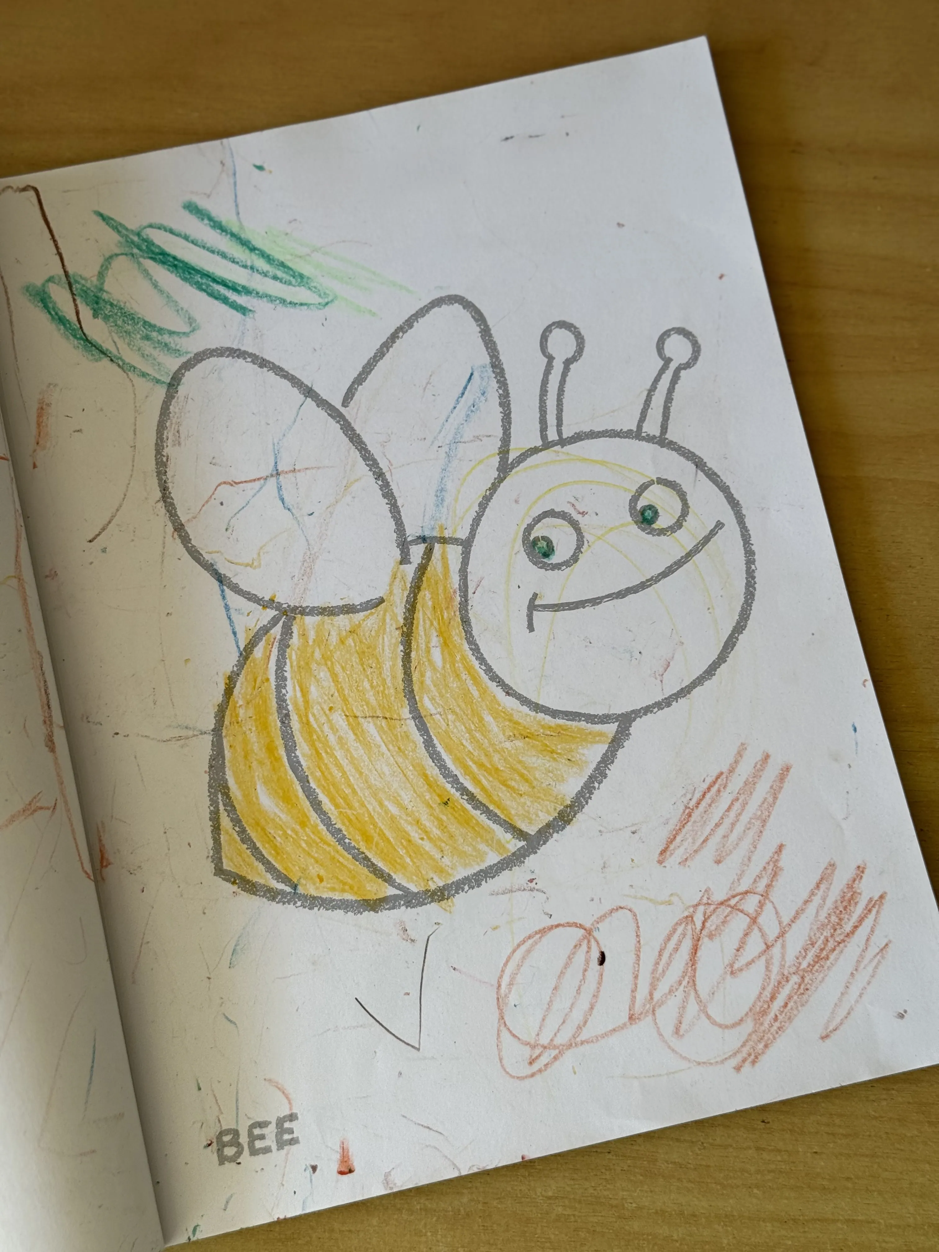 A child's colourful bee drawing on paper